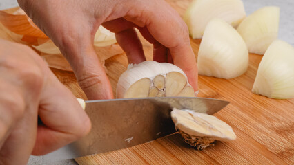 Peeling and cutting garlic on a cutting board. Vegetable soup recipe. Ingredients close-up