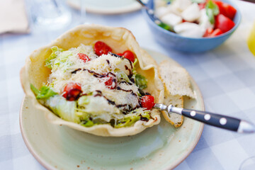 Vegetable salad with grated cheese in a bread plate. 