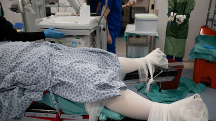 The patient who will be operated on is being prepared for surgery. Woman dressed in sterile clothes...