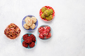 Superfood, raw healthy vegetarian snack, Medjool dates covered by chocolate, and various energy balls with nuts.