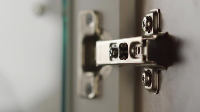 A specialist installs fastenings for the fa&ccedil;ade of cabinet furniture. Close-up
