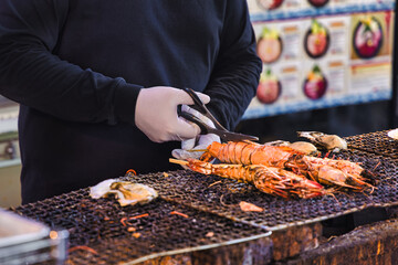 chef at a street kitchen on the Tsukiji market in Tokyo prepares lobster