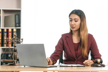 Young Asian female lawyer people reviewing legal documents at desk, embodying reliability,...