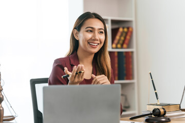 Young Asian female lawyer people reviewing legal documents at desk, embodying reliability, dedication in legal profession, reading announcement. Court convicting defendant according to criminal law