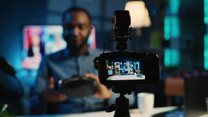 Tech content creator filming technology review of newly released gaming VR glasses for audience. African american influencer showing virtual reality goggles to subscribers