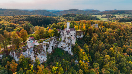 Naklejka premium Aerial drone view medieval Lichtenstein castle on mountain, autumn Baden-Wurttemberg, Germany.