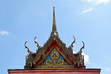 Fototapeta premium BANGKOK, THAILAND - October 22, 2023 : Part of the Roof of a temple in Thailand. Traditional Thai style pattern on the roof of a temple with Blue Sky Background.