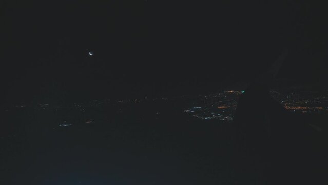 View of Lights of Night City and moon from Plane