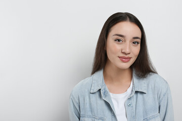 Fototapeta premium Portrait of beautiful young woman in jeans jacket on white background. Space for text