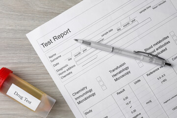 Drug test result form, container with urine sample and pen on wooden table, flat lay