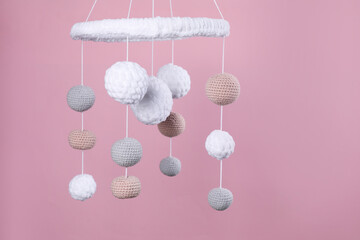 Cute baby crib mobile on pink background