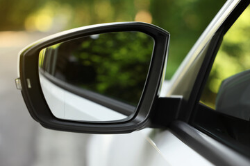 Side view mirror of modern car on blurred background, closeup