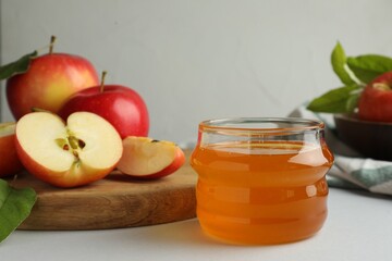 Sweet honey and fresh apples on white table, selective focus. Space for text