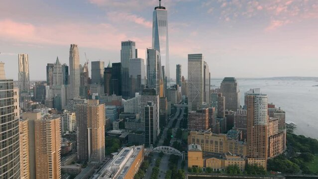 Breathtaking panorama of Financial district on lower Manhattan during golden sunset. Epic aerial of New York with scenic modern skyscrapers and pink clouds on motion background. Rockefeller park USA