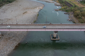 ドローン撮影：信濃川の上にかかる橋と、その上を走る車	