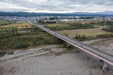 ドローン撮影：信濃川の上にかかる橋と、その上を走る車	