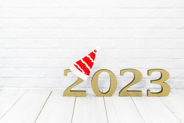 Obraz premium 2023 new year and christmas hat on white wood table over white background with copy space