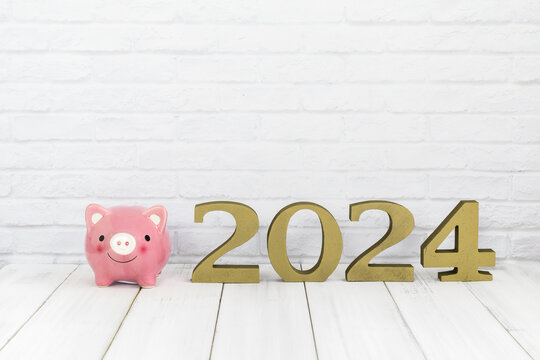 2024 new year and  piggy bank on white wood table over white background with copy space , saving concept