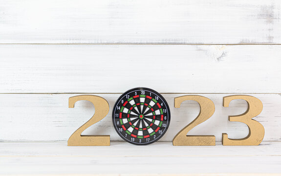 Upcoming 2023 New Year with Dartboard over white wood background, Target and Mission Conccept.