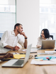 Coworkers smiling and talking during business meeting