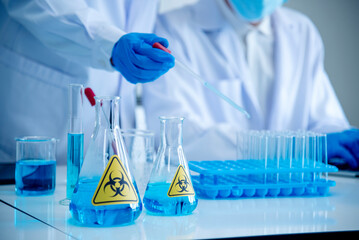 Scientist man holding sample blood test tube in science laboratory. Doctor clinic healthcare technician lab testing blood sample diagnosis. Asian man scientist working in hiv testing medical lab.