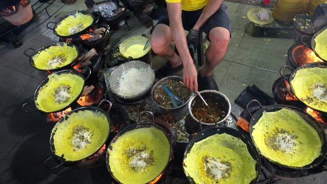 Vietnam food, banh xeo or vietnamese pancakes being fried under hot coals, they are made with rice flour and filled with a soya bean sprouts, is popular Viet Nam street food