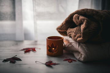 Autumn cozy home background. Candle near window