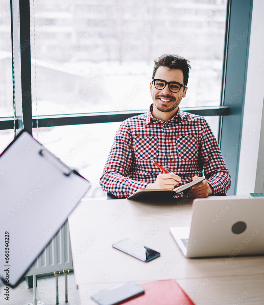 Poster successful employee sitting at desktop with netbook and enjoying cooperation