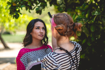The beauty of preparation: a make-up artist getting a beautiful and young brunette model ready for...
