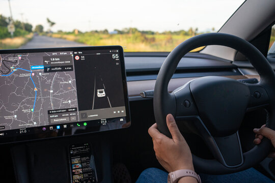 Side view of traveller woman driver using navigator in car screen while driving modern car