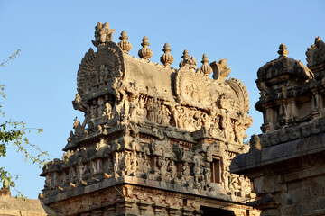 Fototapeta premium Tower of Airavatesvara Temple, Darasuram, Kumbakonam, Tamilnadu. Ancient hindu temple tower with carvings of God sculpture isolated against blue sky background in Tamilnadu.