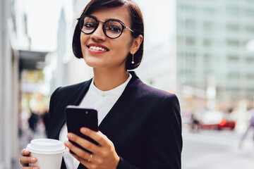  happy smiling woman in formal wear holding modern smartphone device