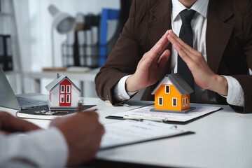 Businessman, lawyer, legal advisor sitting at work holding model home. Protect home, insurance,...