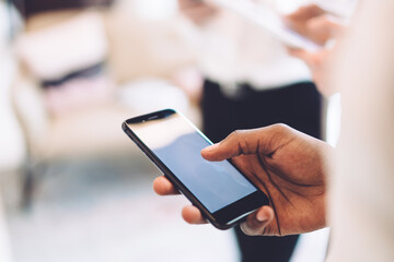 Ethnic person using smartphone at work