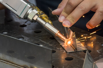 Close up scene the laser welding process with the sparking light.