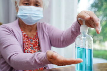 Asian senior woman press blue alcohol sanitizer gel for washing hand protect infection coronavirus. - obrazy, fototapety, plakaty