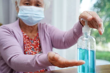  Asian senior woman press blue alcohol sanitizer gel for washing hand protect infection coronavirus. © manassanant