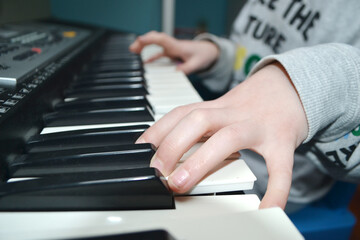 Close up of happy woman's hand playing the piano in the morning.