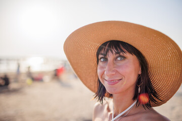 Portrait of an attractive blonde woman with black hair posing on the beach against the backdrop of the sunset.