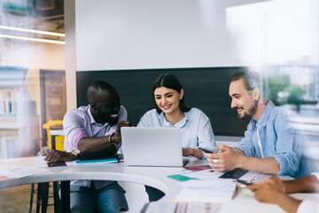 Multiethnic workers discussing ideas and smiling in light office