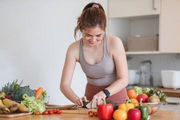 Obraz na płótnie Canvas Sporty young woman is preparing healthy food on light kitchen. healthy food concept.