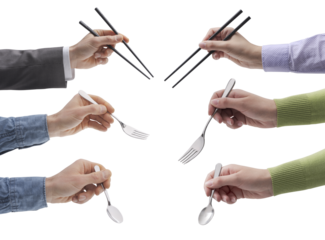 Set of hands holding chopsticks, forks and spoons