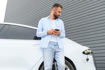 Man standing by his electric car
