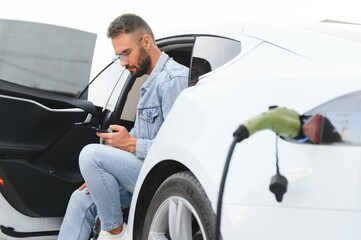 a man charges an electric car