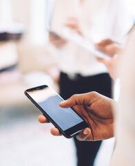 Ethnic person using smartphone at work