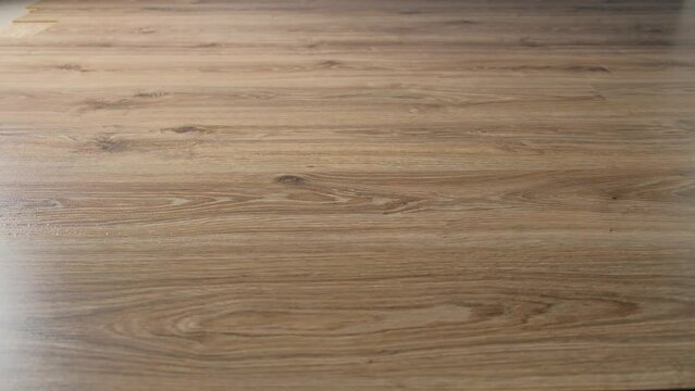 A spilled glass of water on a laminate floor is cleaned up with a mop close-up.