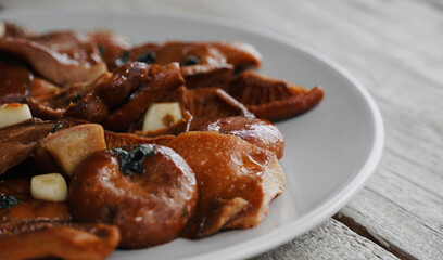 Edible mushrooms Rovellons or Niscalos. Plate of mushrooms and wooden table with copyspace. 