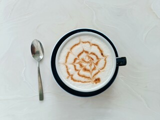 Blue cup of coffee with cinnamon foam and cobweb, halloween