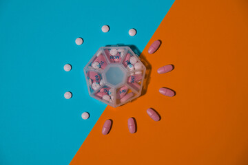 Organizer weekly shots medical pill box with doses of tablets for daily take medicine with white pink drugs and capsules. Copy space Daily vitamins at home. Medication dietary supplements, immunity