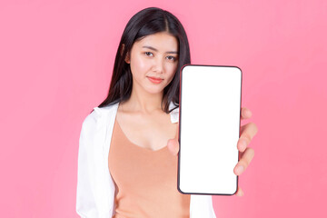 Obraz premium beautiful Asian young woman showing smart phone with blank screen , white screen for Mobile App Advertising isolated on pink background